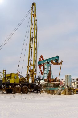 Madencilik ve taş ocağı. Dünya'nın bağırsaklarından yağ çıkarma için kurulumlar. Pumpjack bir yağ kuyusunda pistonlu pompa için yer üstü sürücü. 
