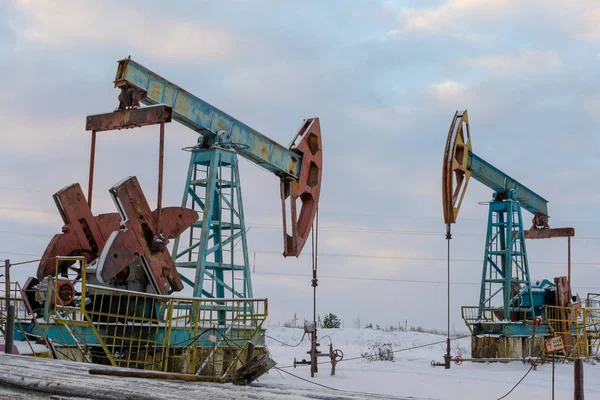 Madencilik ve taş ocağı. Dünya'nın bağırsaklarından yağ çıkarma için kurulumlar. Pumpjack bir yağ kuyusunda pistonlu pompa için yer üstü sürücü. — Stok fotoğraf