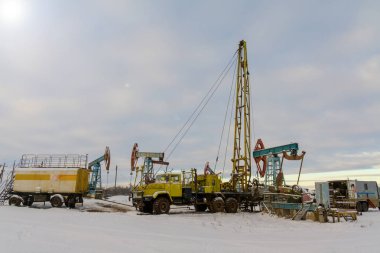 Madencilik ve taş ocağı. Dünya'nın bağırsaklarından yağ çıkarma için kurulumlar. Pumpjack bir yağ kuyusunda pistonlu pompa için yer üstü sürücü. 