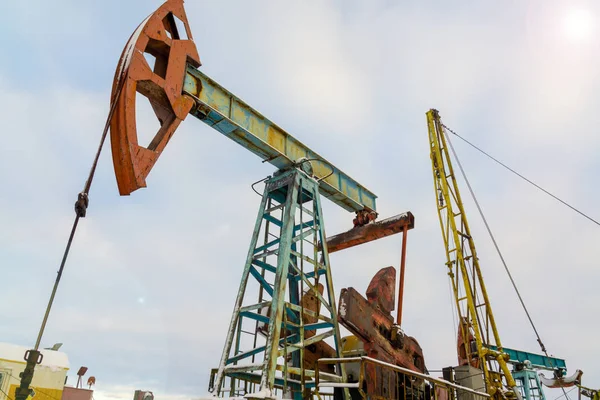 Madencilik ve taş ocağı. Dünya'nın bağırsaklarından yağ çıkarma için kurulumlar. Pumpjack bir yağ kuyusunda pistonlu pompa için yer üstü sürücü. — Stok fotoğraf