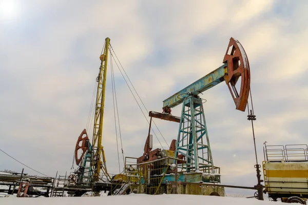 Madencilik ve taş ocağı. Dünya'nın bağırsaklarından yağ çıkarma için kurulumlar. Pumpjack bir yağ kuyusunda pistonlu pompa için yer üstü sürücü. — Stok fotoğraf