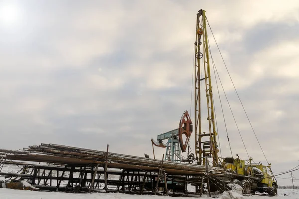 Mines et carrières. Installations pour l'extraction du pétrole des entrailles de la Terre. Pumpjack est l'entraînement hors sol pour une pompe à piston à piston alternatif dans un puits d'huile . — Photo