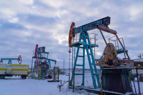 Industrie pétrolière et gazière. Pompes à huile Silhouette sur fond de ciel couchant. Équipement de l'industrie pétrolière. Fermer Vue industrielle de l'usine de raffinage de pétrole de la zone industrielle — Photo