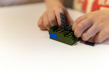 Küçük çocuk odada yapıcı yla oynuyor. Yalnızlık kavramı, beklentiler, yetim bir çocuk, bir yetimhane. Bir anaokulundan eğitim görüntüsü: masasında oyuncaklarla oynayan çocuk