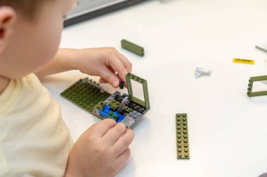 Küçük çocuk odada yapıcı yla oynuyor. Yalnızlık kavramı, beklentiler, yetim bir çocuk, bir yetimhane. Bir anaokulundan eğitim görüntüsü: masasında oyuncaklarla oynayan çocuk