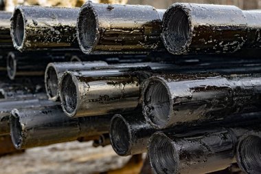 Petrol sondaj borusu. Paslı matkap boruları kuyu bölümünden delinmiş. Delik sondaj kulesi. Güverteye boru döşemek. Petrol ve benzin deposunun avlusundaki sondaj borularının görüntüsü.