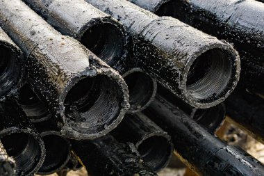 Petrol sondaj borusu. Paslı matkap boruları kuyu bölümünden delinmiş. Delik sondaj kulesi. Güverteye boru döşemek. Petrol ve benzin deposunun avlusundaki sondaj borularının görüntüsü.