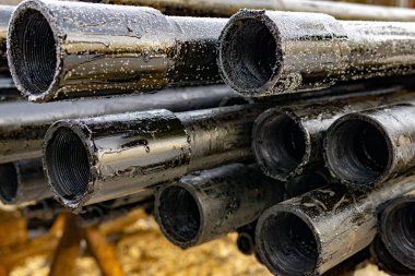 Petrol sondaj borusu. Paslı matkap boruları kuyu bölümünden delinmiş. Delik sondaj kulesi. Güverteye boru döşemek. Petrol ve benzin deposunun avlusundaki sondaj borularının görüntüsü.