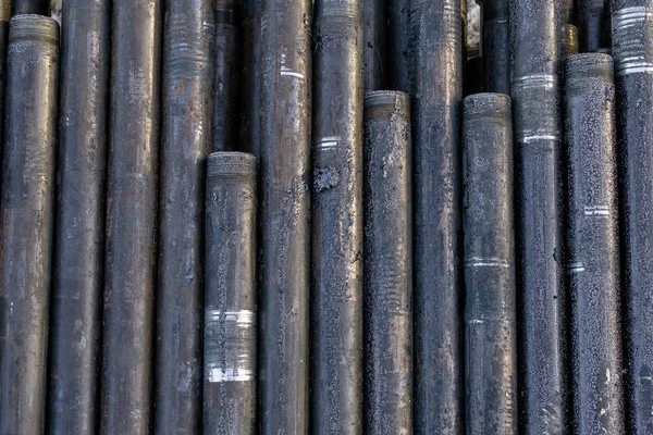 Industria offshore de petróleo y gas de producción de oleoducto. Plataforma de perforación de pozos. Colocando la tubería en la cubierta. Vista de la cáscara de las tuberías de perforación colocadas en el patio del almacén de petróleo y gas — Foto de Stock