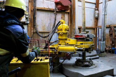 Offshore petrol kuyusu işçisi kuyu başındaki petrol kuyusunda delik açmak için alet ve ekipman hazırlayın. Sondaj borusu bağlantısı kuruyorum. Tribünlerin arasından matkap borusu bağlantısı için bir görünüm.