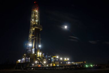 Petrol ve doğalgaz sondaj kulesi dramatik bulutlu tatlı sahnesinde. Petrol ve doğalgaz endüstrisindeki petrol platformunda sondaj sondajı çalışması.