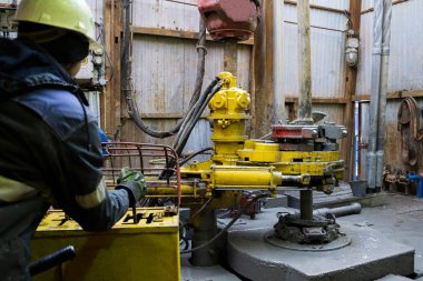 Offshore petrol kuyusu işçisi kuyu başındaki petrol kuyusunda delik açmak için alet ve ekipman hazırlayın. Sondaj borusu bağlantısı kuruyorum. Tribünlerin arasından matkap borusu bağlantısı için bir görünüm.