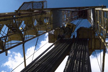 Petrol ve doğalgaz sondaj kulesi dramatik bulutlu tatlı sahnesinde. Petrol ve doğalgaz endüstrisindeki petrol platformunda sondaj sondajı çalışması.