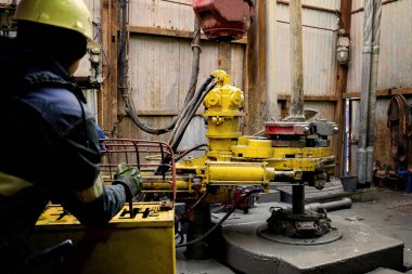 Offshore petrol kuyusu işçisi kuyu başındaki petrol kuyusunda delik açmak için alet ve ekipman hazırlayın. Sondaj borusu bağlantısı kuruyorum. Tribünlerin arasından matkap borusu bağlantısı için bir görünüm.
