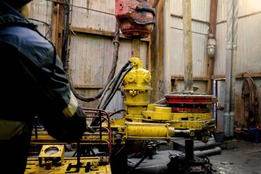 Offshore petrol kuyusu işçisi kuyu başındaki petrol kuyusunda delik açmak için alet ve ekipman hazırlayın. Sondaj borusu bağlantısı kuruyorum. Tribünlerin arasından matkap borusu bağlantısı için bir görünüm.