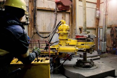 Offshore petrol kuyusu işçisi kuyu başındaki petrol kuyusunda delik açmak için alet ve ekipman hazırlayın. Sondaj borusu bağlantısı kuruyorum. Tribünlerin arasından matkap borusu bağlantısı için bir görünüm.