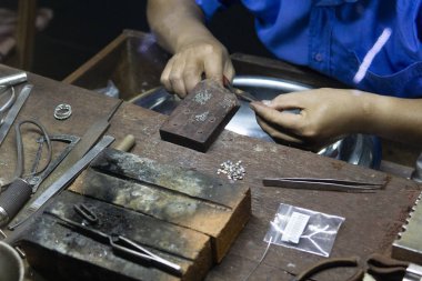 Bir kolye üzerinde inci dizme yakın el kuyumcu. İnci Kolye üretiminde işçi 