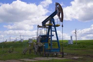 Işın pompalama ünitesi ev ödevi, petrol alanında gün batımı. Petrol pompası petrol platformu enerji sanayi makinesi petrol için. Pompa olarak pompa ünitesi bir kuyuya monte edilmiştir. Petrol yataklarının ekipmanları.