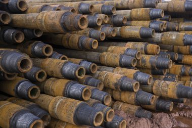 Petrol ve gaz kuyularının sondajı. Matkap borusu denetimi. Yıkandıktan ve kontrole hazır landıktan sonra kuyuların kaidesi üzerinde listelenen petrol ve gaz boruları. Güvertede döşeme kovan yığını