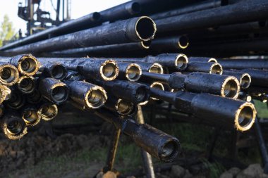 Petrol sondaj borusu. Paslı matkap boruları kuyu bölümünden delinmiş. Delik sondaj kulesi. Güverteye boru döşemek. Petrol ve benzin deposunun avlusundaki sondaj borularının görüntüsü