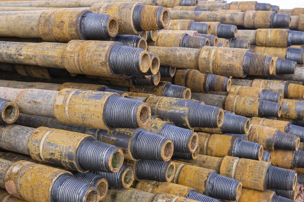 Forage de puits de pétrole et de gaz. Inspection des tuyaux de forage. Tubes pour le pétrole et le gaz énumérés sur le piédestal hors des puits après le lavage et prêt pour l'inspection. Empilement de carter posé sur le pont — Photo