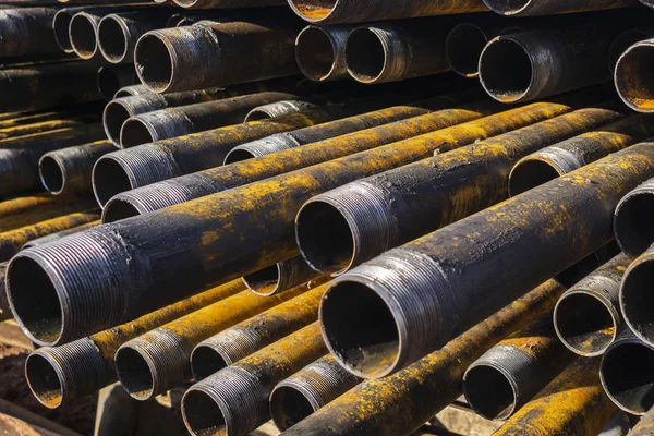 Forage de puits de pétrole et de gaz. Inspection des tuyaux de forage. Tubes pour le pétrole et le gaz énumérés sur le piédestal hors des puits après le lavage et prêt pour l'inspection. Empilement de carter posé sur le pont — Photo