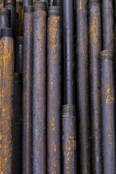 Tubo di trivella. Tubi di perforazione arrugginiti sono stati perforati nella sezione del pozzo. Impianto di perforazione. Posa il tubo sul ponte. Vista del guscio di tubi di perforazione prevista nel cortile del magazzino di petrolio e gas — Foto Stock