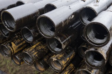 Petrol sondaj borusu. Paslı matkap boruları kuyu bölümünden delinmiş. Delik sondaj kulesi. Güverteye boru döşemek. Petrol ve benzin deposunun avlusundaki sondaj borularının görüntüsü