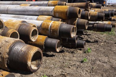 Petrol sondaj borusu. Paslı matkap boruları kuyu bölümünden delinmiş. Delik sondaj kulesi. Güverteye boru döşemek. Petrol ve benzin deposunun avlusundaki sondaj borularının görüntüsü