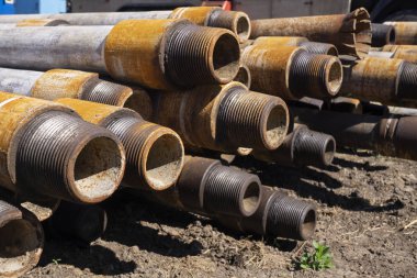 Petrol sondaj borusu. Paslı matkap boruları kuyu bölümünden delinmiş. Delik sondaj kulesi. Güverteye boru döşemek. Petrol ve benzin deposunun avlusundaki sondaj borularının görüntüsü