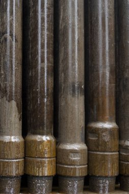 Petrol sondaj borusu. Paslı matkap boruları kuyu bölümünden delinmiş. Delik sondaj kulesi. Güverteye boru döşemek. Petrol ve benzin deposunun avlusundaki sondaj borularının görüntüsü