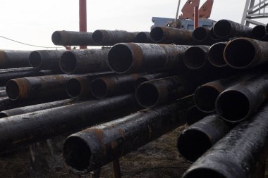 Petrol sondaj borusu. Paslı matkap boruları kuyu bölümünden delinmiş. Delik sondaj kulesi. Güverteye boru döşemek. Petrol ve benzin deposunun avlusundaki sondaj borularının görüntüsü
