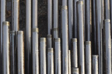 Petrol sondaj borusu. Paslı matkap boruları kuyu bölümünden delinmiş. Delik sondaj kulesi. Güverteye boru döşemek. Petrol ve benzin deposunun avlusundaki sondaj borularının görüntüsü