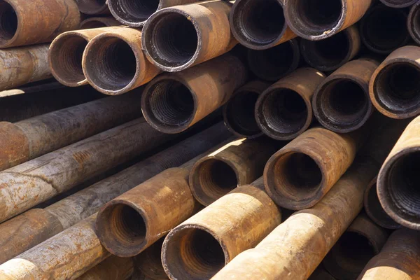 Oil Drill pipe. Rusty drill pipes were drilled in the well section. Downhole drilling rig. Laying the pipe on the deck. View of the shell of drill pipes laid in courtyard of the oil and gas warehouse