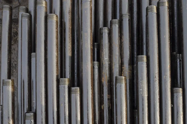 Oil Drill pipe. Rusty drill pipes were drilled in the well section. Downhole drilling rig. Laying the pipe on the deck. View of the shell of drill pipes laid in courtyard of the oil and gas warehouse — Stock Photo, Image