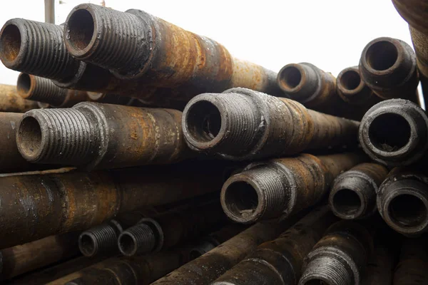 Oil Drill pipe. Rusty drill pipes were drilled in the well section. Downhole drilling rig. Laying the pipe on the deck. View of the shell of drill pipes laid in courtyard of the oil and gas warehouse — Stock Photo, Image