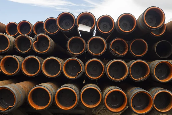 Oil Drill pipe. Rusty drill pipes were drilled in the well section. Downhole drilling rig. Laying the pipe on the deck. View of the shell of drill pipes laid in courtyard of the oil and gas warehouse