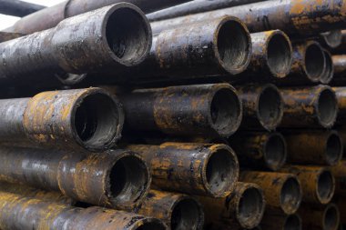 Petrol sondaj borusu. Paslı matkap boruları kuyu bölümünden delinmiş. Delik sondaj kulesi. Güverteye boru döşemek. Petrol ve benzin deposunun avlusundaki sondaj borularının görüntüsü.