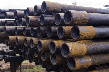 Petrol sondaj borusu. Paslı matkap boruları kuyu bölümünden delinmiş. Delik sondaj kulesi. Güverteye boru döşemek. Petrol ve benzin deposunun avlusundaki sondaj borularının görüntüsü.