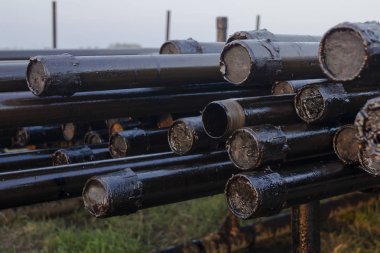 Petrol sondaj borusu. Paslı matkap boruları kuyu bölümünden delinmiş. Delik sondaj kulesi. Güverteye boru döşemek. Petrol ve benzin deposunun avlusundaki sondaj borularının görüntüsü.