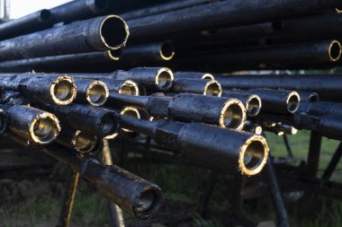 Petrol sondaj borusu. Paslı matkap boruları kuyu bölümünden delinmiş. Delik sondaj kulesi. Güverteye boru döşemek. Petrol ve benzin deposunun avlusundaki sondaj borularının görüntüsü.