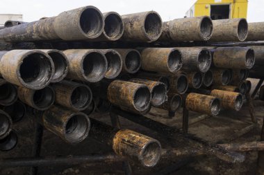 Petrol sondaj borusu. Paslı matkap boruları kuyu bölümünden delinmiş. Delik sondaj kulesi. Güverteye boru döşemek. Petrol ve benzin deposunun avlusundaki sondaj borularının görüntüsü.