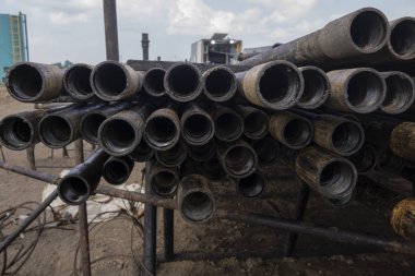 Petrol sondaj borusu. Paslı matkap boruları kuyu bölümünden delinmiş. Delik sondaj kulesi. Güverteye boru döşemek. Petrol ve benzin deposunun avlusundaki sondaj borularının görüntüsü.