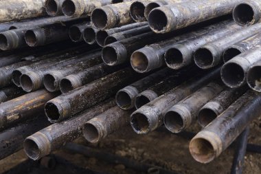 Petrol sondaj borusu. Paslı matkap boruları kuyu bölümünden delinmiş. Delik sondaj kulesi. Güverteye boru döşemek. Petrol ve benzin deposunun avlusundaki sondaj borularının görüntüsü.