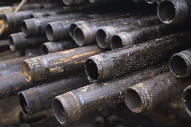 Petrol sondaj borusu. Paslı matkap boruları kuyu bölümünden delinmiş. Delik sondaj kulesi. Güverteye boru döşemek. Petrol ve benzin deposunun avlusundaki sondaj borularının görüntüsü.