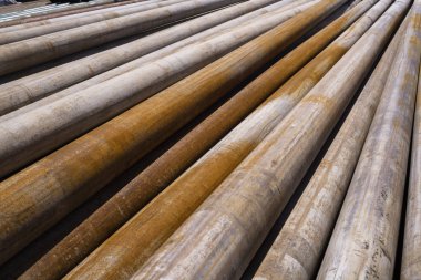 Petrol sondaj borusu. Paslı matkap boruları kuyu bölümünden delinmiş. Delik sondaj kulesi. Güverteye boru döşemek. Petrol ve benzin deposunun avlusundaki sondaj borularının görüntüsü.