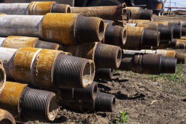 Petrol sondaj borusu. Paslı matkap boruları kuyu bölümünden delinmiş. Delik sondaj kulesi. Güverteye boru döşemek. Petrol ve benzin deposunun avlusundaki sondaj borularının görüntüsü.