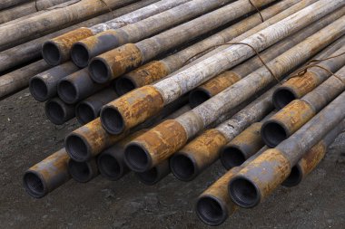 Petrol sondaj borusu. Paslı matkap boruları kuyu bölümünden delinmiş. Delik sondaj kulesi. Güverteye boru döşemek. Petrol ve benzin deposunun avlusundaki sondaj borularının görüntüsü.