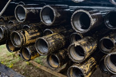 Petrol sondaj borusu. Paslı matkap boruları kuyu bölümünden delinmiş. Delik sondaj kulesi. Güverteye boru döşemek. Petrol ve benzin deposunun avlusundaki sondaj borularının görüntüsü.