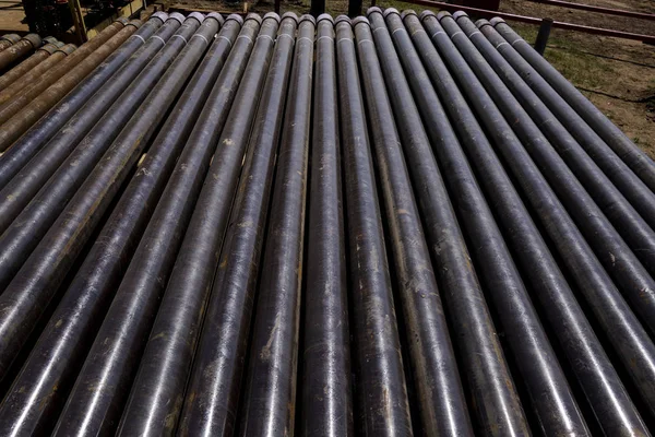 Olie boorpijp. In het putgedeelte werden roestige boorpijpen geboord. Beneden boorplatform. De pijp op het dek leggen. Zicht op de schelp van boorpijpen op de binnenplaats van het olie- en gasmagazijn. — Stockfoto